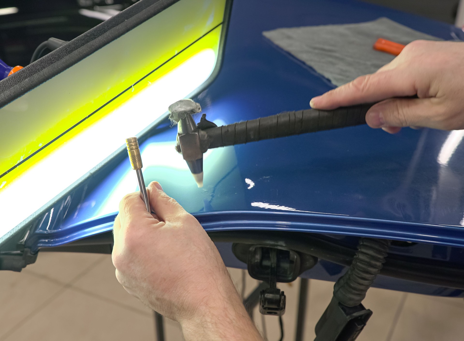 Body repair. PDR. A specialist repairs a dent on the car body without painting.